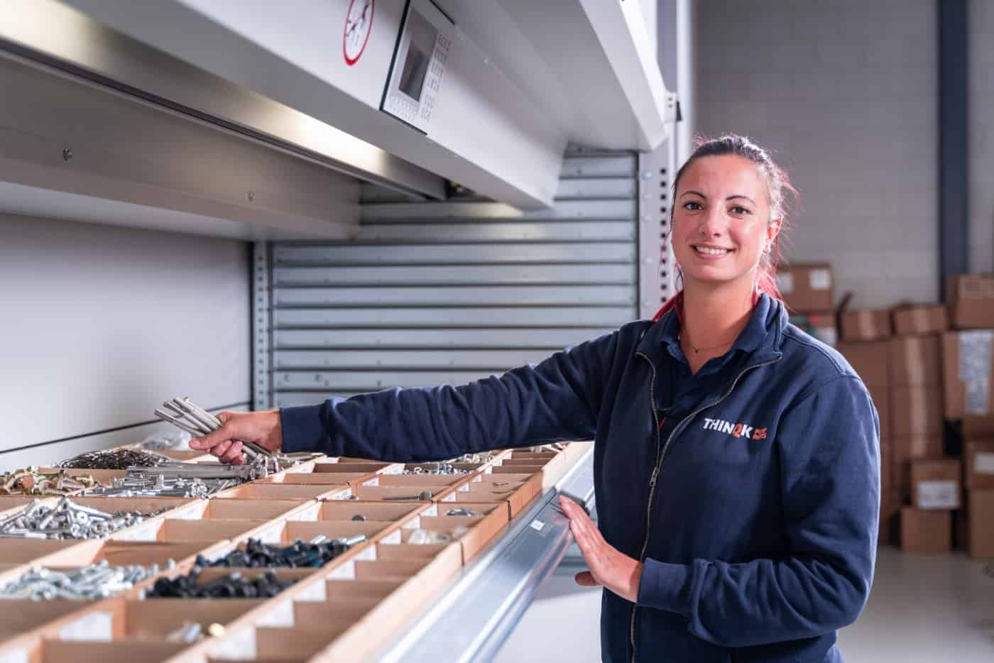 Magazijnmedewerker die onderdelen uit een stelling pakt